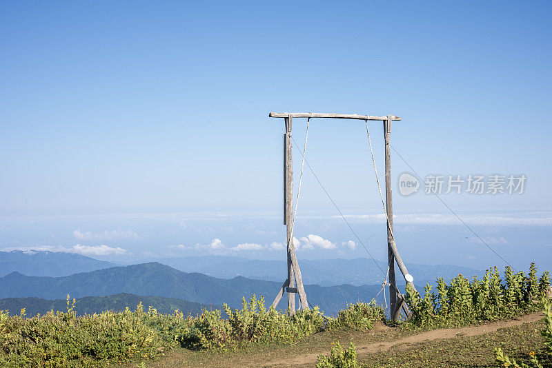 蓝天和山景前的大秋千