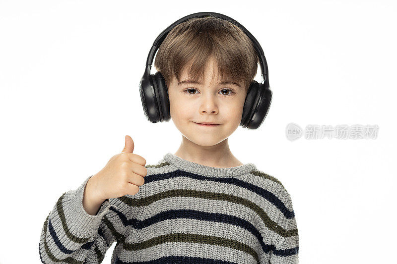 一个可爱的小男孩喜欢用无线耳机听音乐