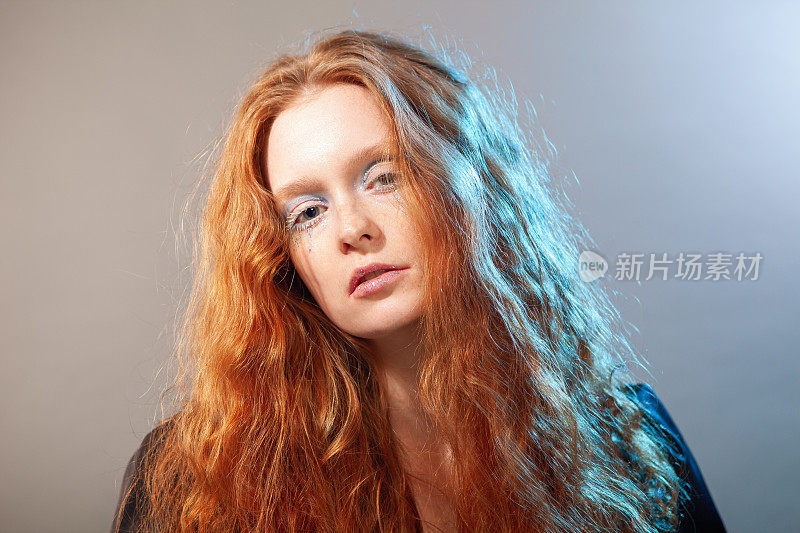 一个年轻漂亮的红发女人的艺术肖像，她的妆容很有艺术感。使用的光效