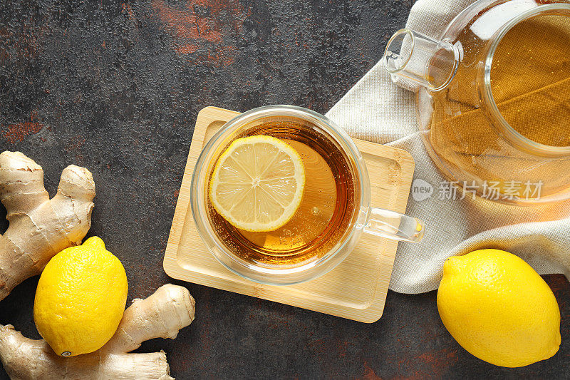 茶杯和茶壶与茶，柠檬和姜在灰色背景，俯视图