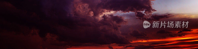 黑色，暗红色，紫色，品红，紫色，蓝色的天空。戏剧性的傍晚日落背景。云风暴风闪电雨。不祥的。横幅。