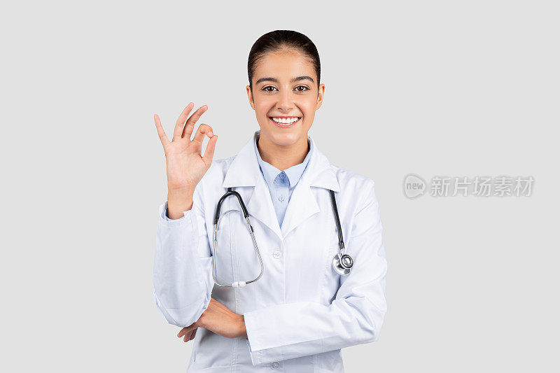 一个阳性的女医生穿着实验室工作服，戴着听诊器