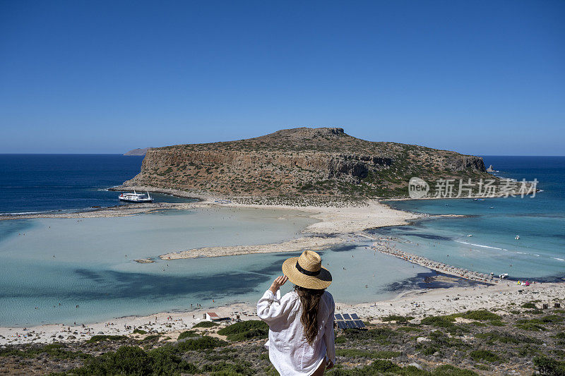 女人俯视着平静的海湾和岛屿