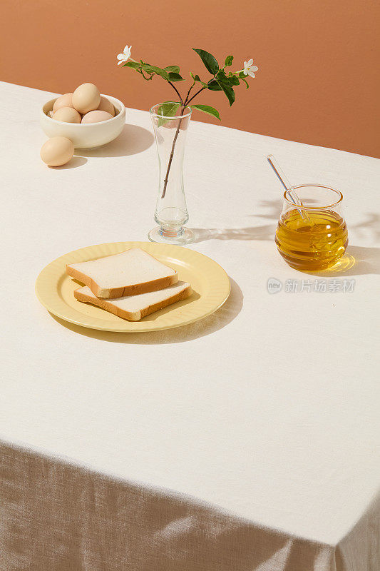 烹饪照片的布局，在空白的白色桌子上有烹饪材料，包括三明治，蜂蜜和鸡蛋。复制空间，俯视图