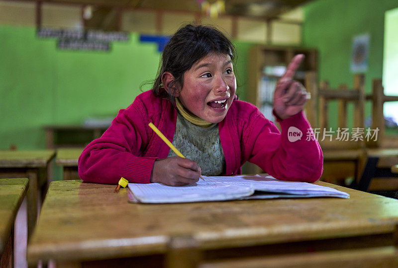 来自奎罗族的克丘亚女孩在学校听老师讲课，指着黑板