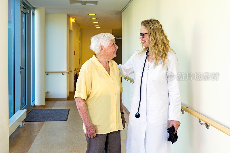 医生和一位年长的女病人聊天。
