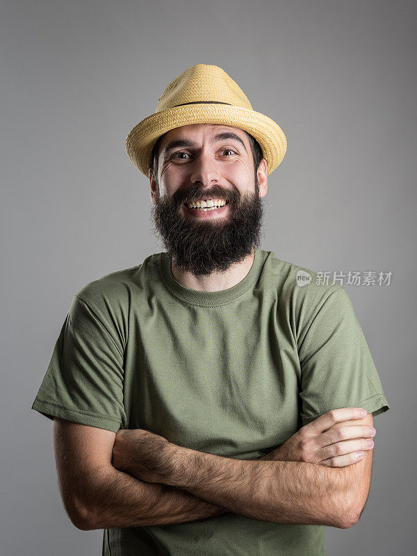 一名戴着草帽的大胡子男子笑着看着镜头