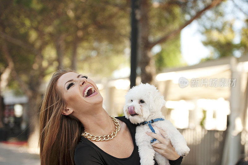 年轻微笑迷人的女人与马耳他贵宾犬