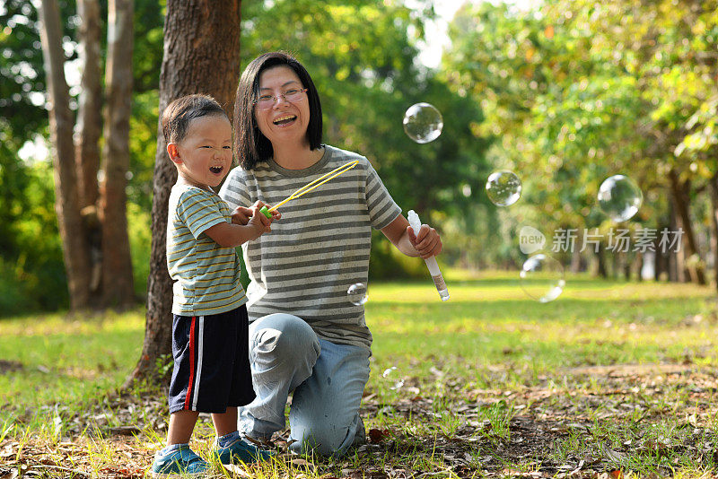 亚洲小孩和妈妈玩泡泡棒