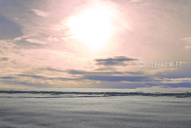 雪地上的痕迹映衬着淡粉色的天空