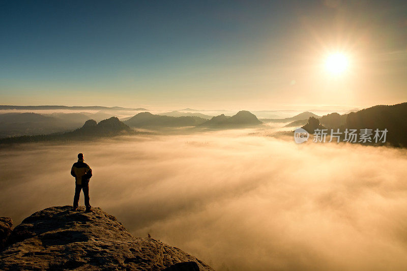 人站在山顶，望着太阳。美丽的奇迹