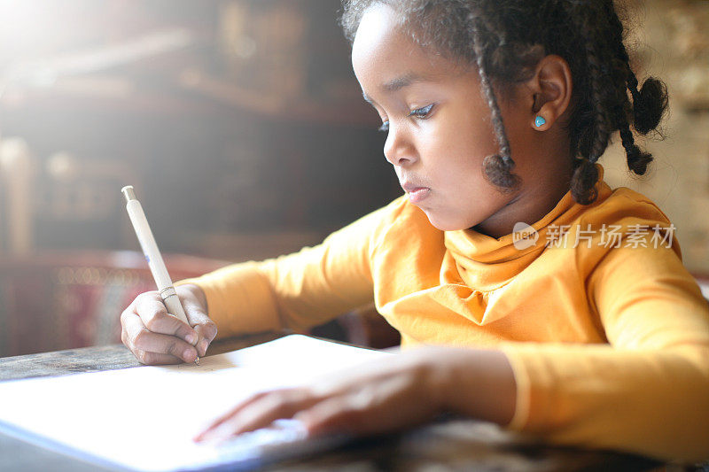 小非洲女孩在写作。