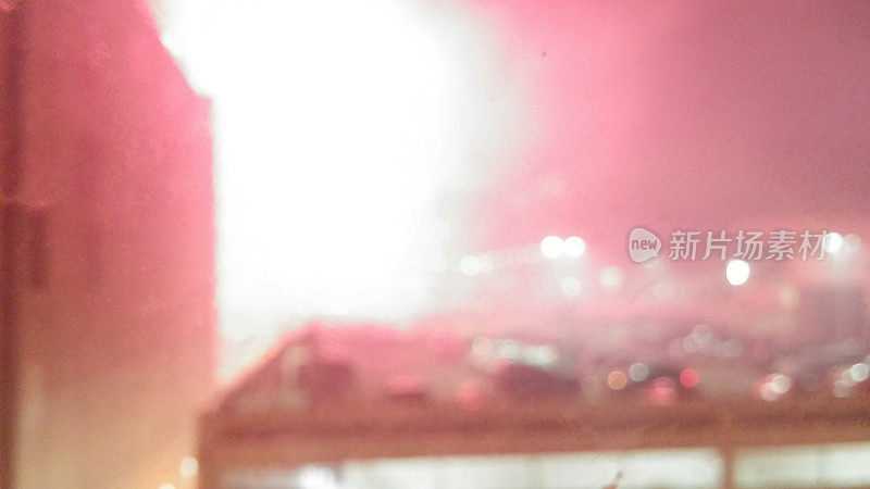 模糊的夜晚停车场屋顶，城市烟花爆炸
