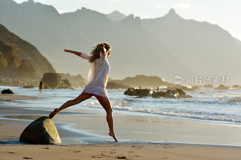 夏天，年轻女子在海滩上蹦蹦跳跳