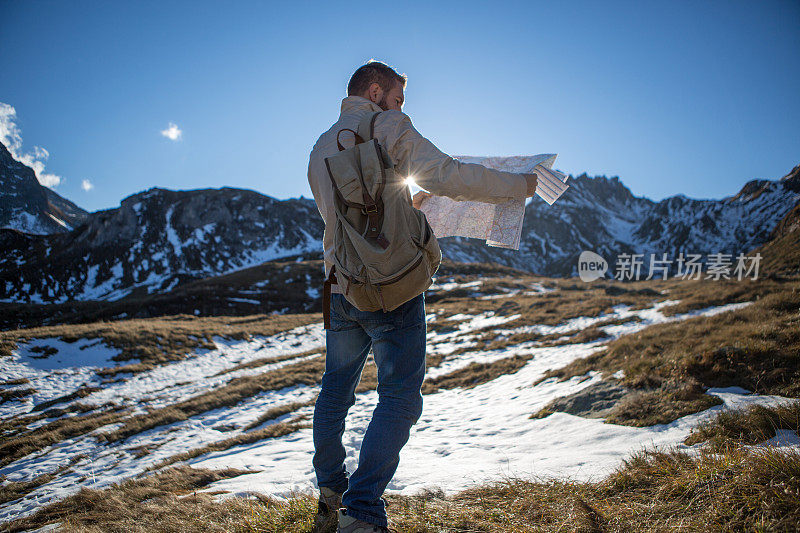 游客在雪山徒步旅行，看地图寻找方向