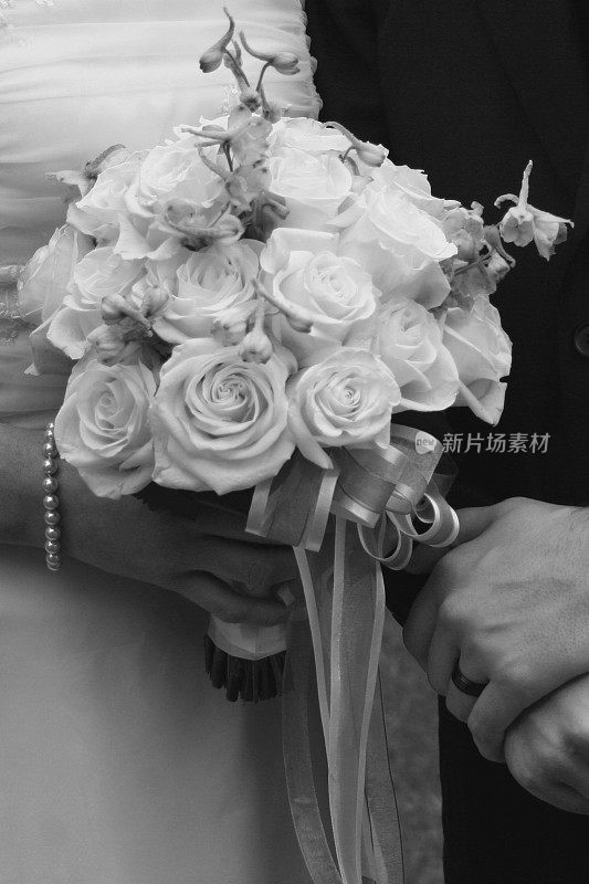 新娘和新郎捧着婚礼花束
