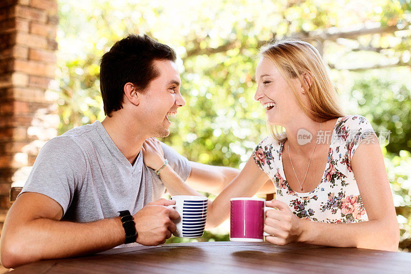 相爱的年轻夫妇一起喝咖啡大笑