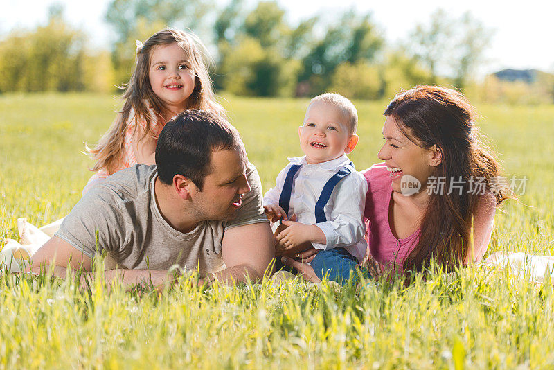 欢乐的家庭在春天的草地上放松和交流。