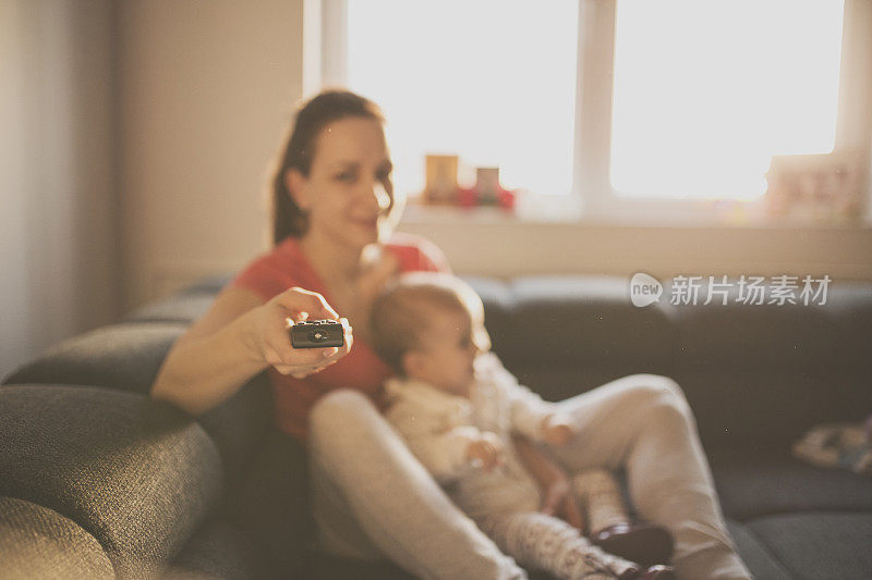 女人和婴儿在看电视