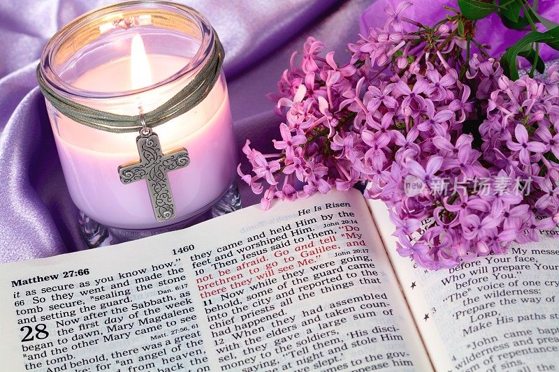节日:复活节圣经配紫色蜡烛和花朵的圣经
