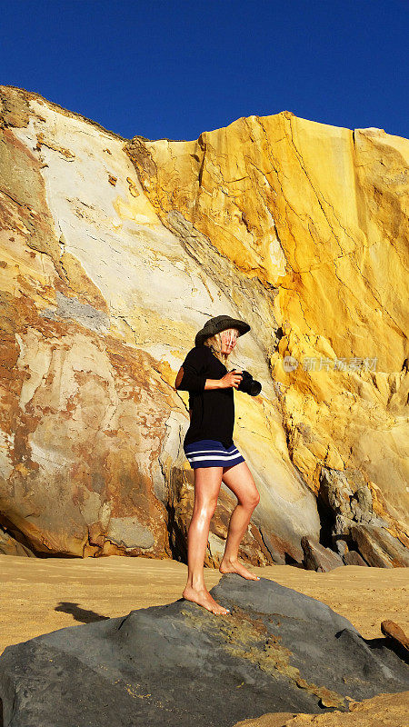女人探索美丽的黄色悬崖