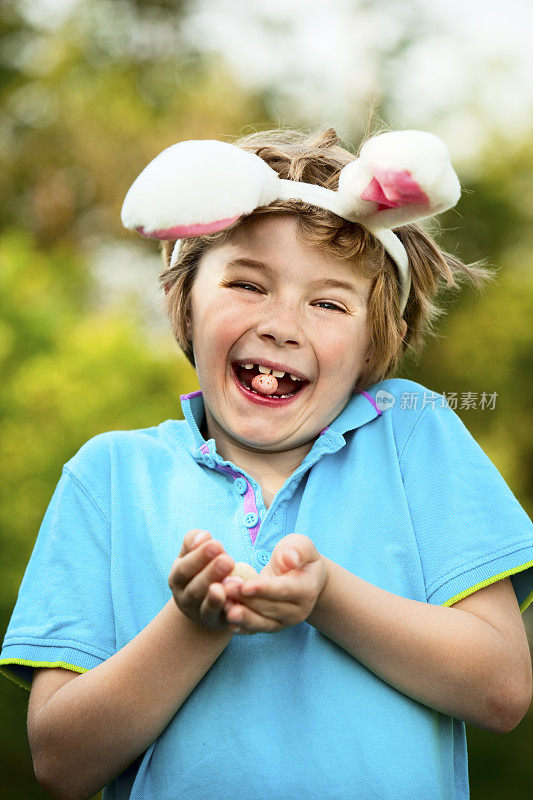长着兔子耳朵的男孩正在成功地寻找复活节彩蛋