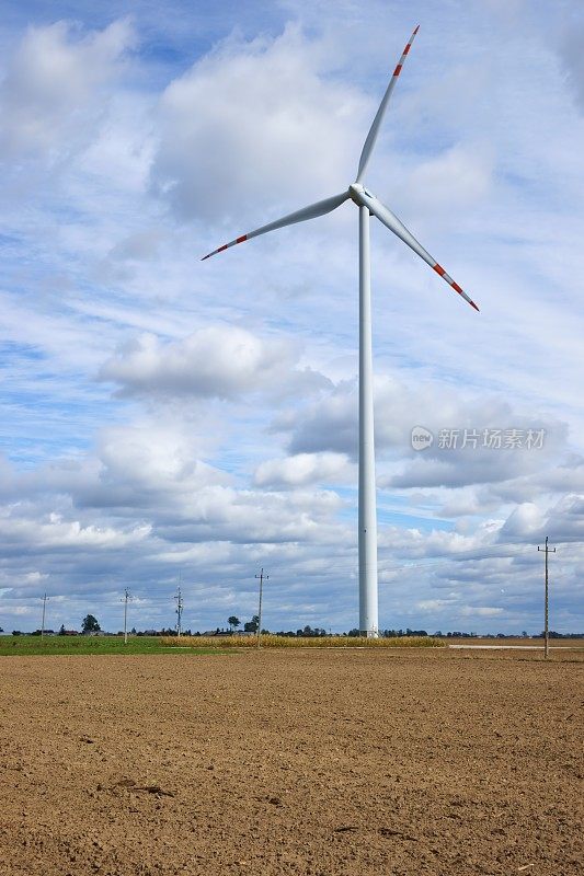 风车，风力涡轮机矗立在犁过的土地上