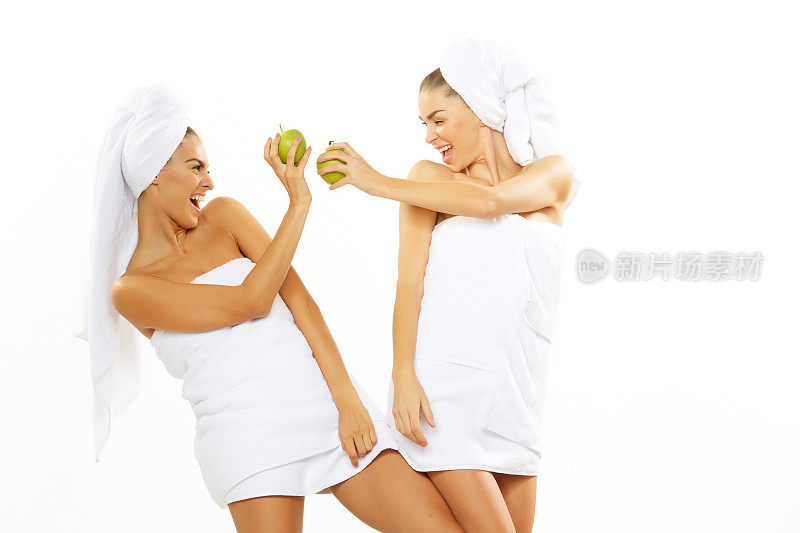 两个快乐的少女淋浴后玩苹果