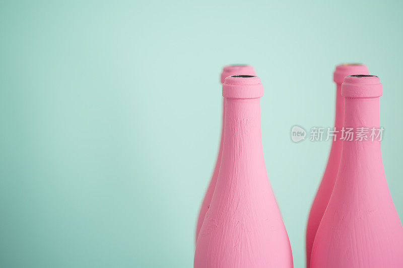 粉红色的瓶子映衬着柔和的绿松石色背景