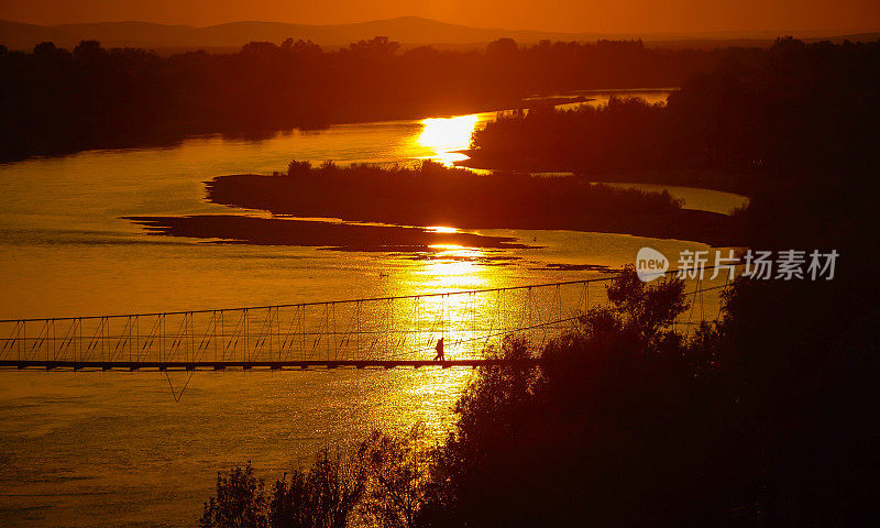 人们走过吊桥，黄金时刻景色，中国新疆风光。
