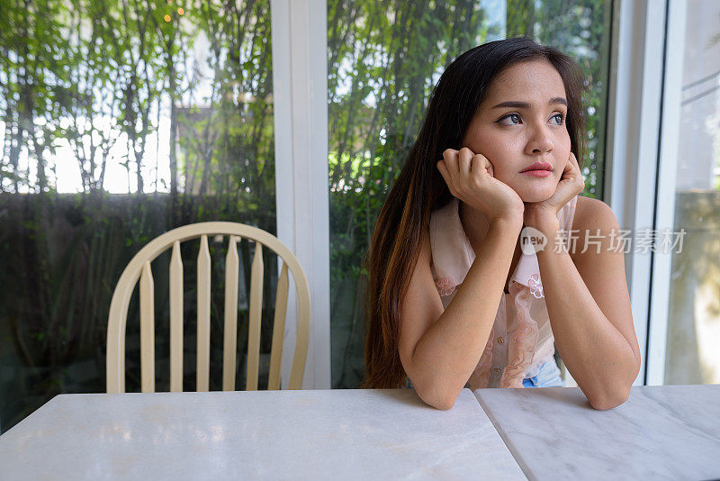 年轻美丽的亚洲女人的肖像放松在泰国曼谷的咖啡店