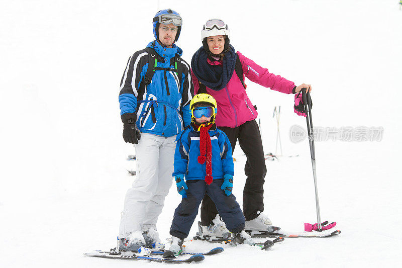 年轻幸福的家庭和一个孩子，在山上滑雪