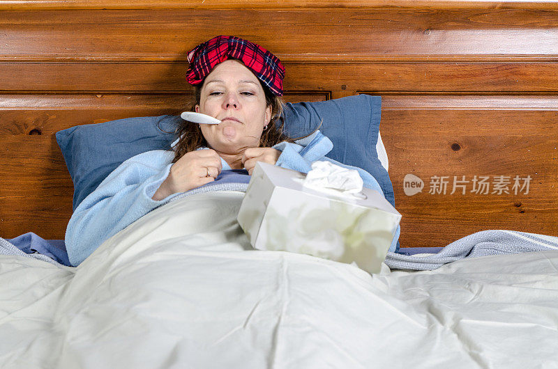 有个女人卧病在床，嘴里叼着温度计，还有一盒纸巾