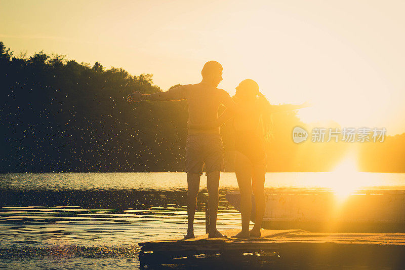 年轻浪漫的夫妇在湖边欣赏日落
