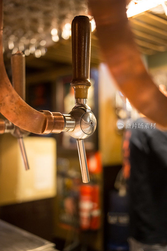 啤酒酒吧酒吧水龙头，柜台与模糊的酒吧背景。布鲁塞尔比利时