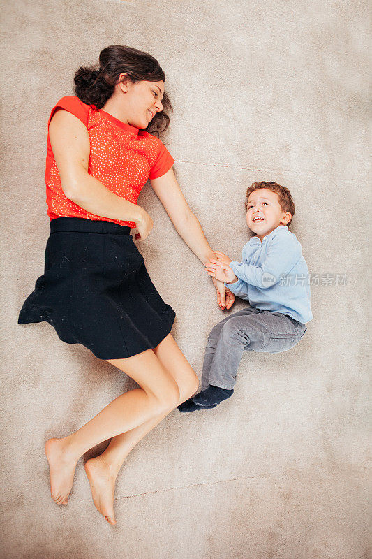 母亲和儿子在家里的地板上玩耍