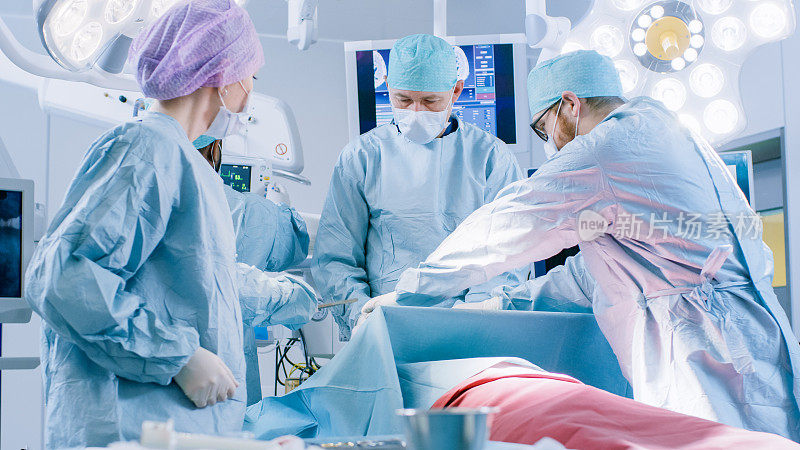 不同的专业外科医生团队在医院手术室对病人进行侵入性手术。外科医生使用和其他仪器，麻醉医生监测生命体征。