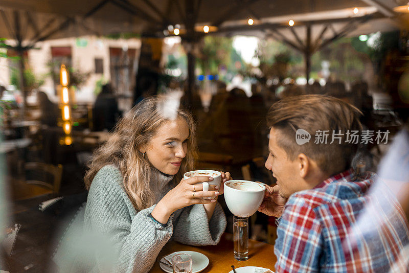 一对年轻夫妇在酒吧里喝咖啡