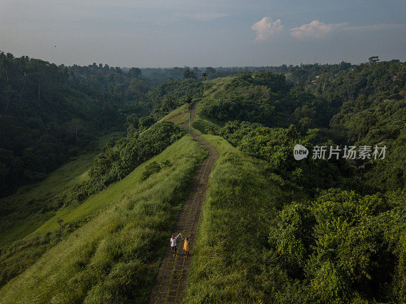 无人机的观点，年轻夫妇走在大米自然散步，乌布-巴厘岛-人们旅游热带目的地爱浪漫的概念