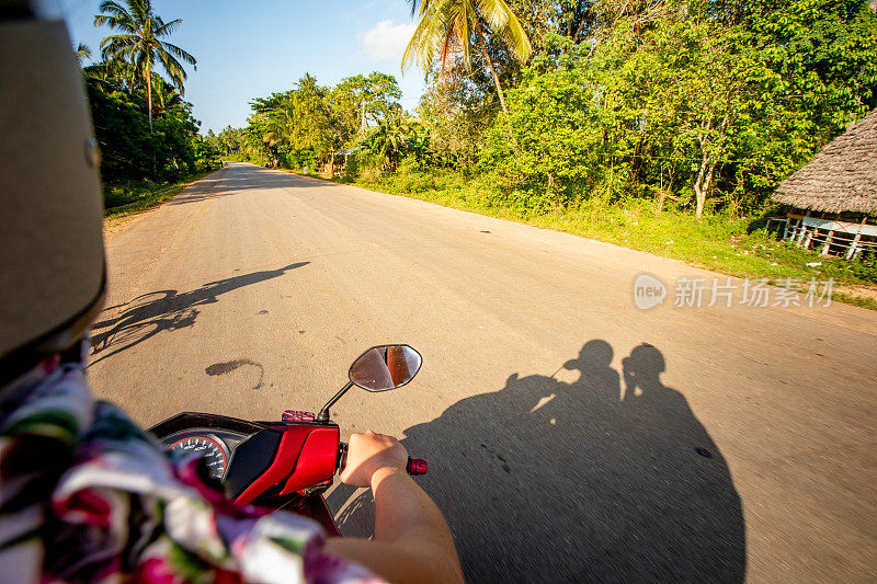 一对游客夫妇骑摩托车探索热带岛屿