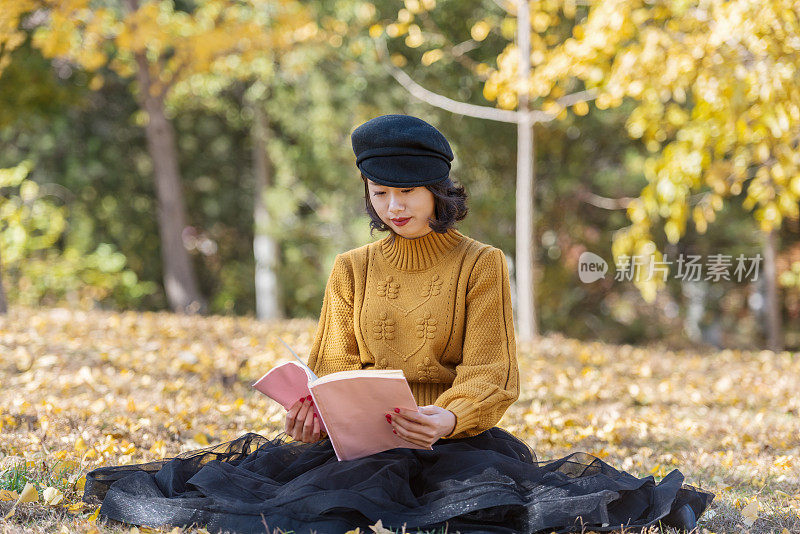 一个亚洲女孩在公园里看书