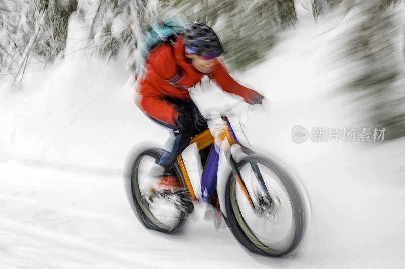 运动模糊的自行车和一个胖子在雪地上超速行驶