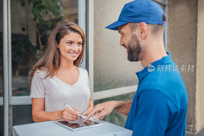 微笑的女人看快递员触摸数字平板电脑