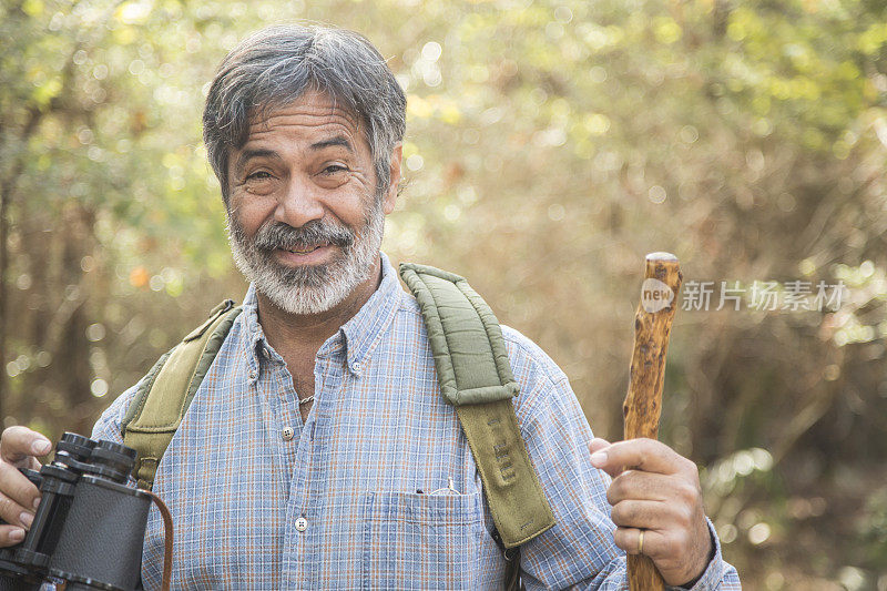 活跃的成年男子在森林地区徒步旅行。