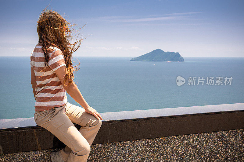 台湾依兰县外澳海滩，一名妇女在欣赏龟山岛的景色