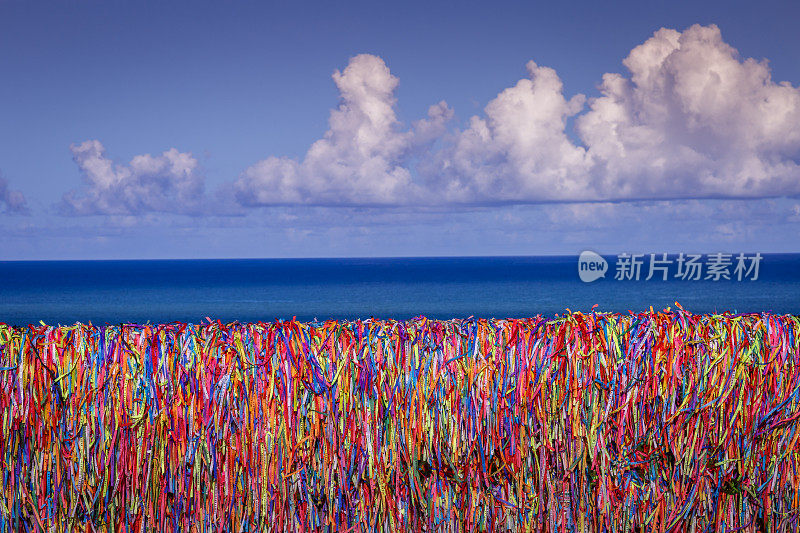 在巴西的巴伊亚港，彩色的邦菲姆许愿带挂在墙上和海滩上