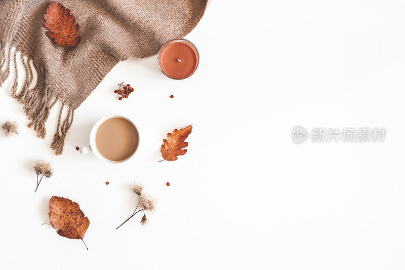 秋天的成分。一杯咖啡，围巾，干叶子，花，白色背景上的月桂浆果。秋天，秋天，感恩节的概念。平铺，俯视图，拷贝空间