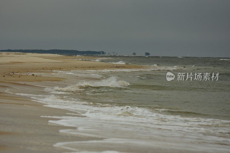 长海滩，海浪和远处的树木在炎热的烟雾