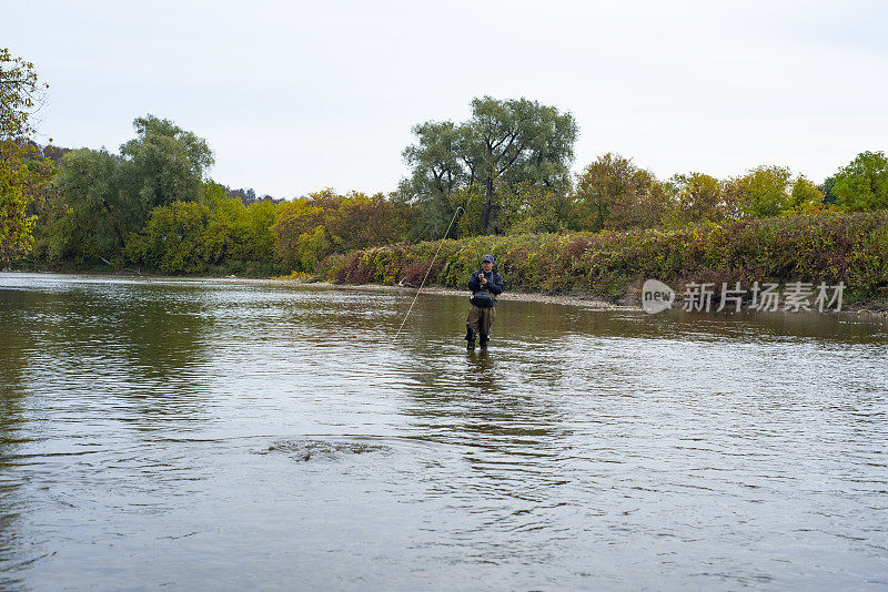 一个年轻的渔民正在和他用钓竿钩住的奇努克鲑鱼搏斗。