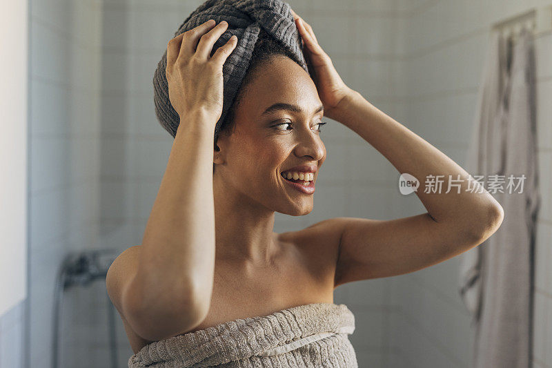 美丽的非洲裔美国女人裹在毛巾洗澡后
